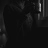 Winter blues and the clocks going back A woman looking out of a window with a warm drink on a grey winter morning